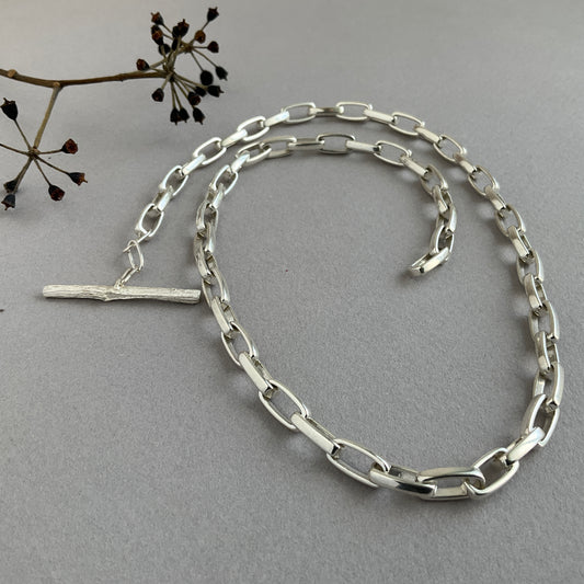 Tierra collection chunky chain recycled sterling silver with mono casted twig clasp handcrafted in London grey background seeds twig on the left side