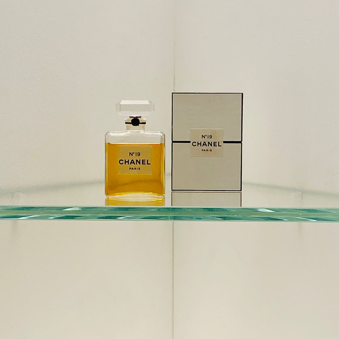 Picture of Chanel 19 perfume on a shelve with the carboard box next to it part of the exhibition at the V&A Museum London