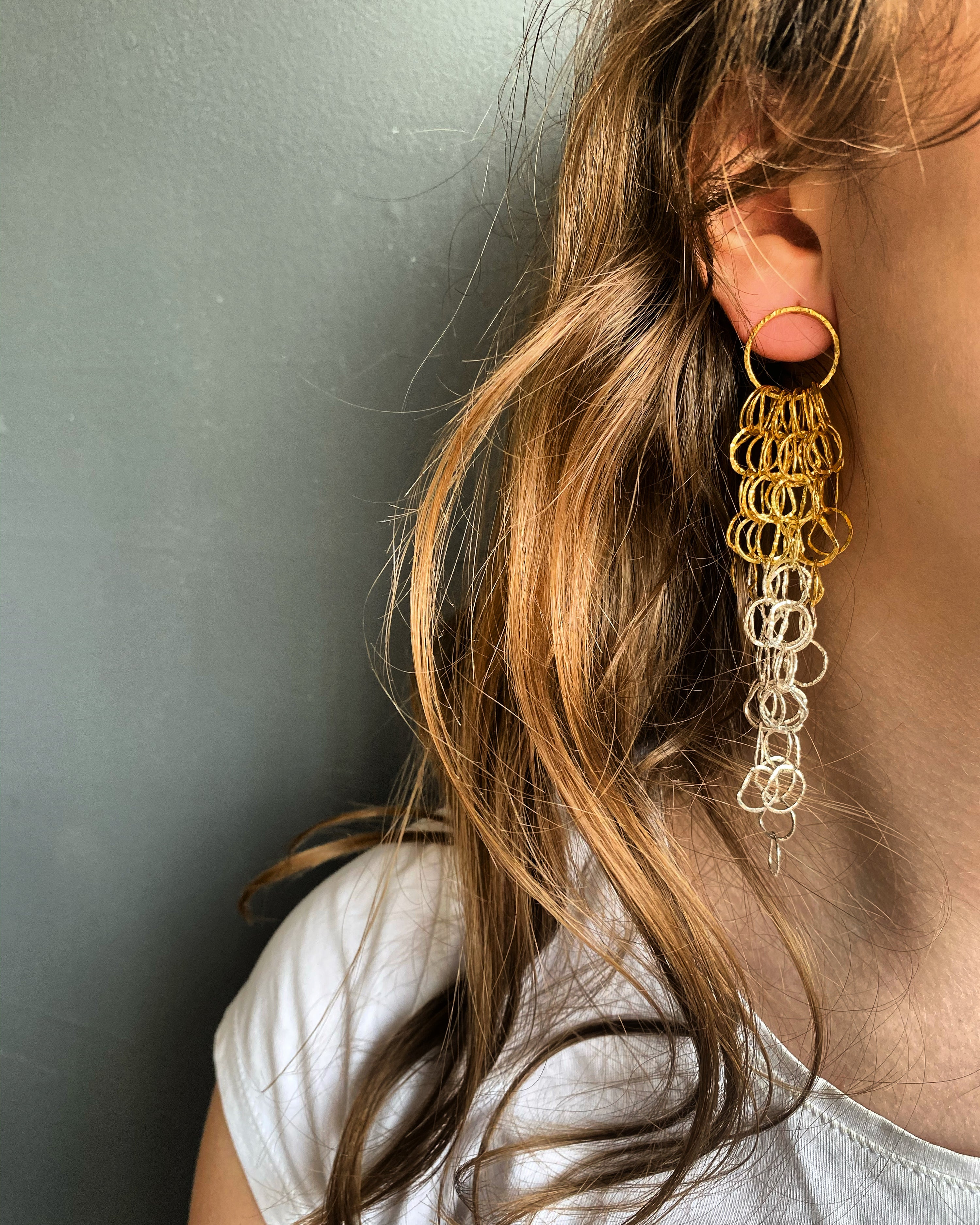 Afiok large long cascade earrings in two toned recycled 24ct yellow gold vermeil and sterling silver modelled with long brown hair side profile