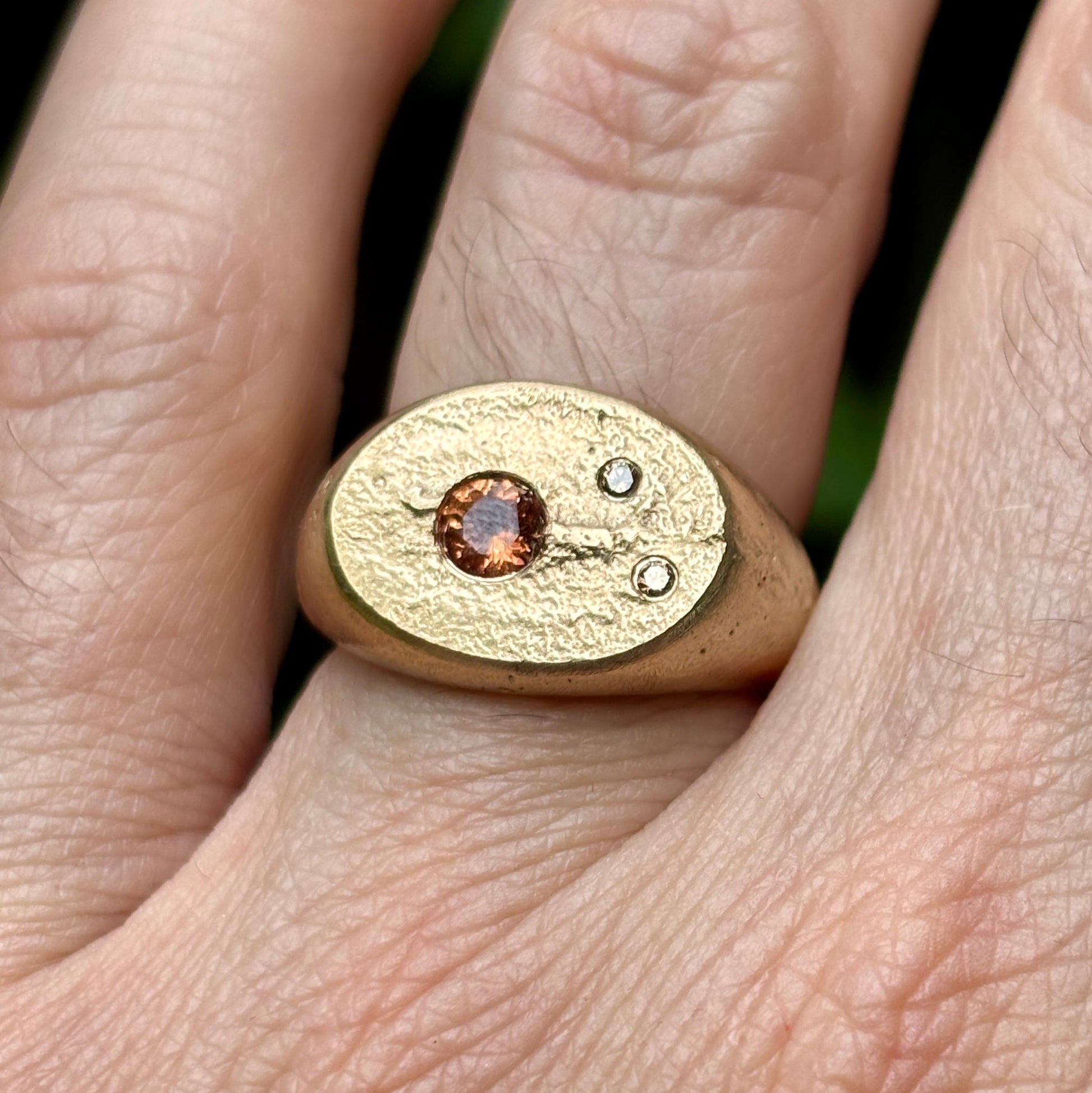 Gold ring with a gemstone on a person's finger